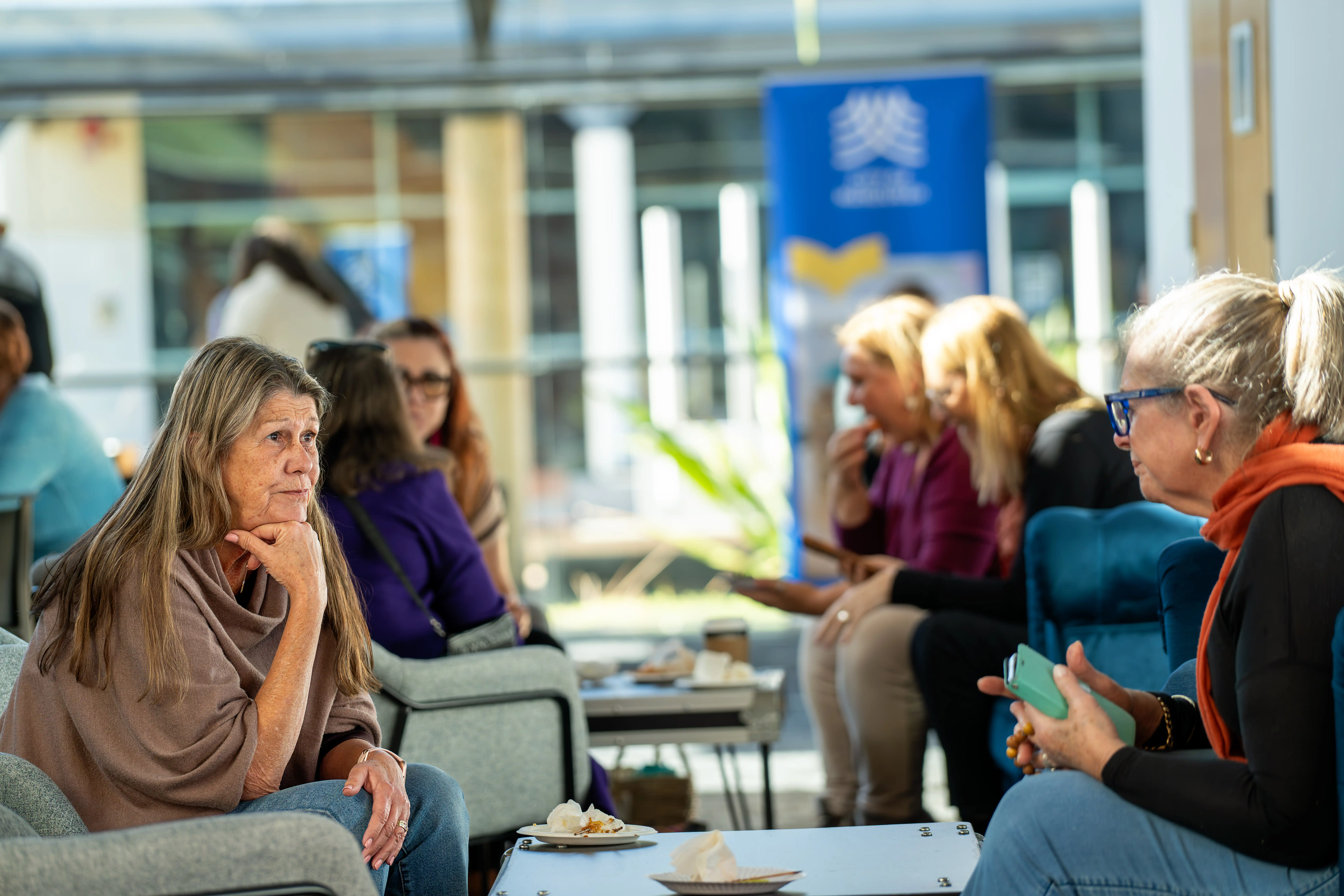 People seated in a lounge area having conversations around low tables